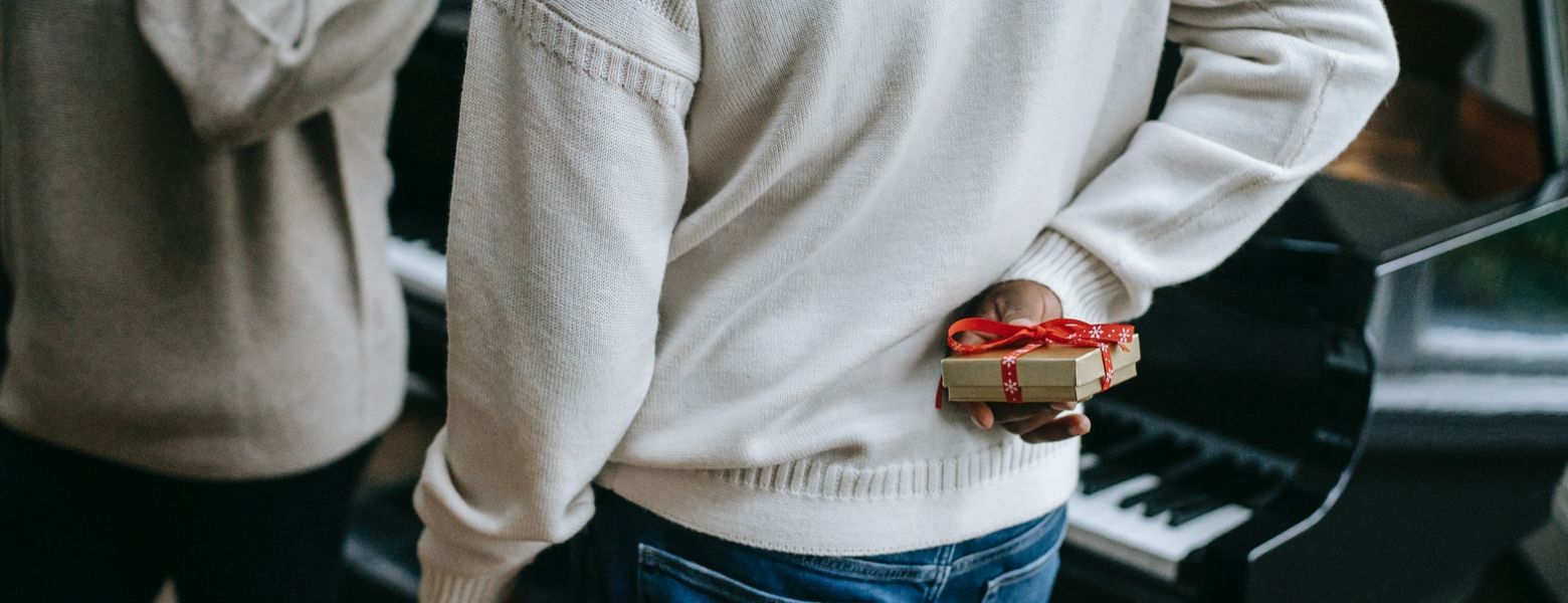 man holding a gift behind his back