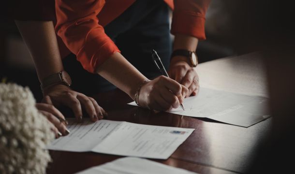 signing documents on a table, indoors
