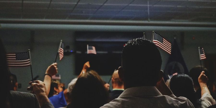people in a room holding usa flags, indoors