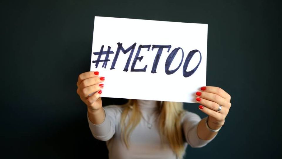 #metoo sign being held by a woman indoors