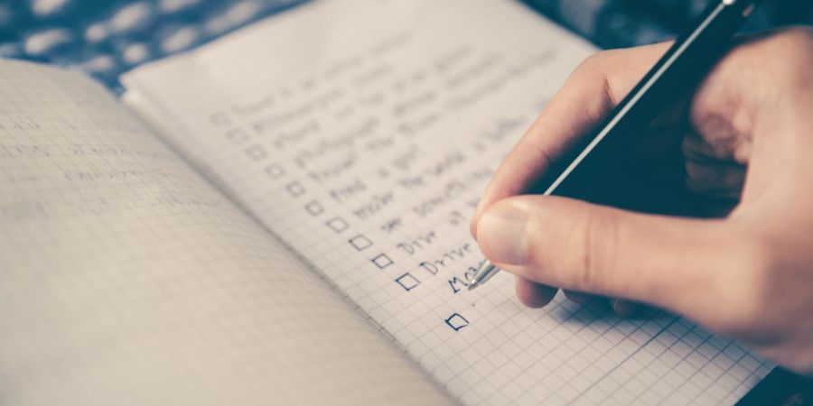 person making a checklis in a notebook, indoors
