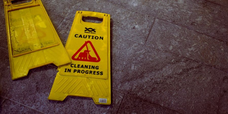 caution cleaning signs laying on the ground flat