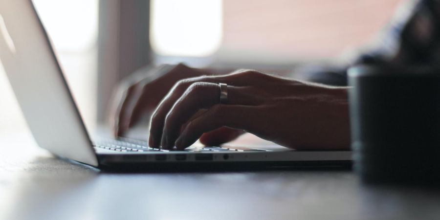 person typing on a laptop indoors