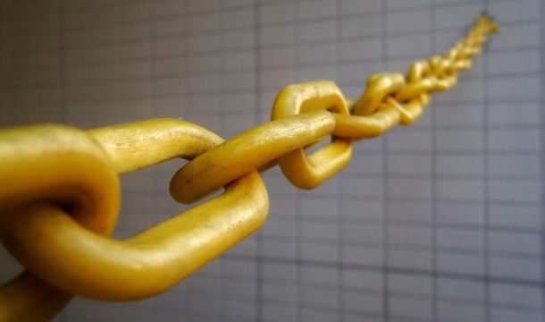 golden chain stretched out from brick like wall