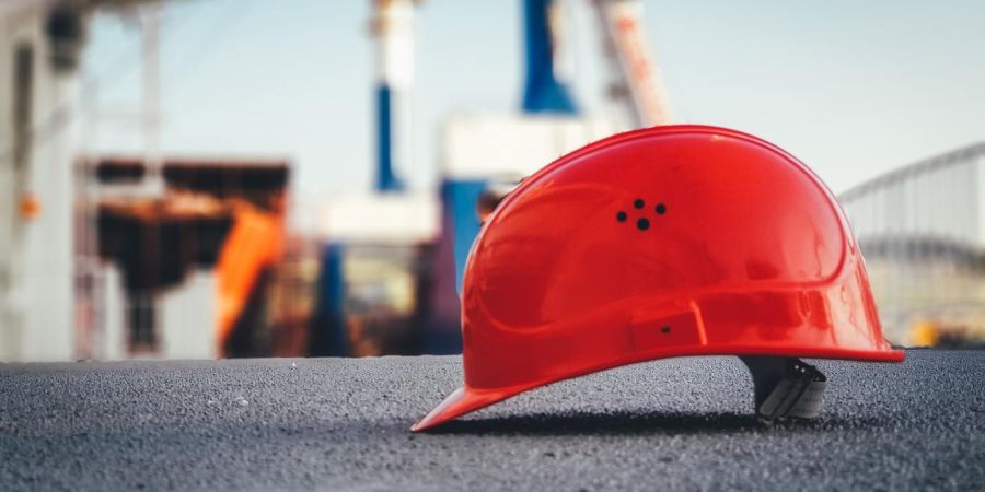 red safety helmet sitting on the ground, outdoors