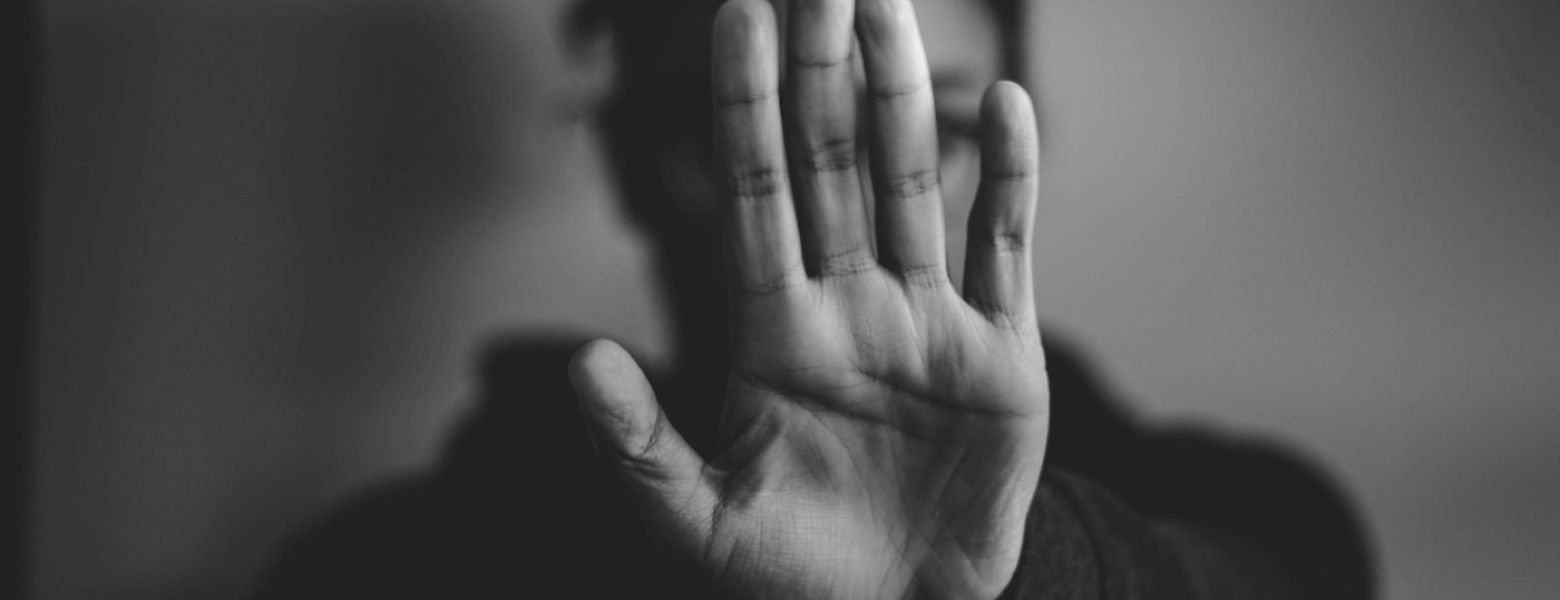 person holding up a hand, stop, indoors