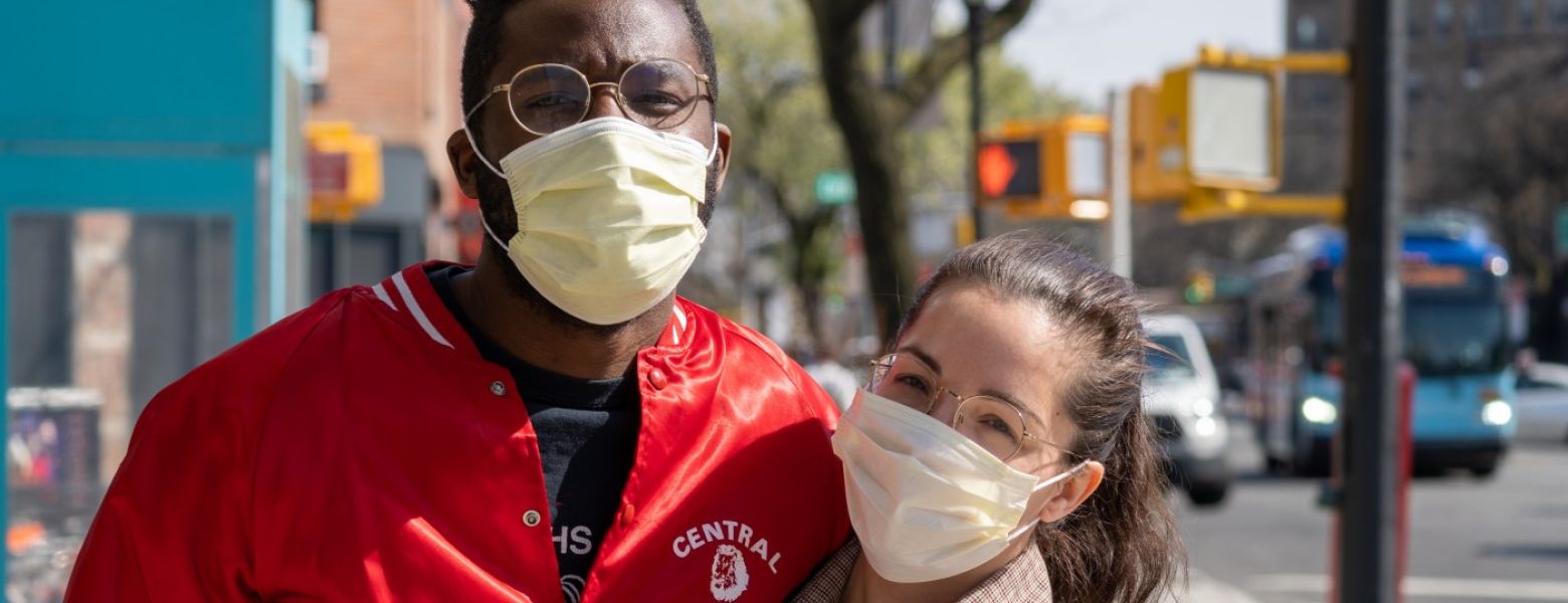 a couple embracing outside while wearing masks