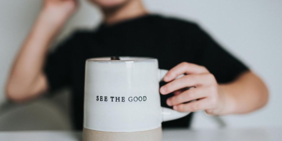 holding a be the good mug, indoors