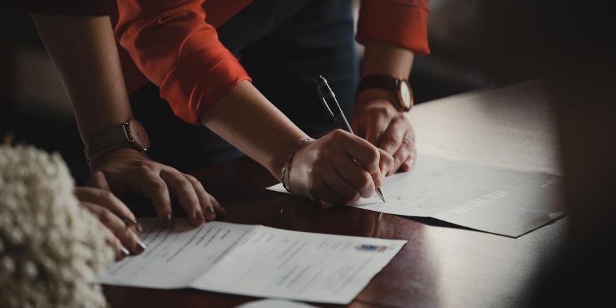 signing documents on a table, indoors