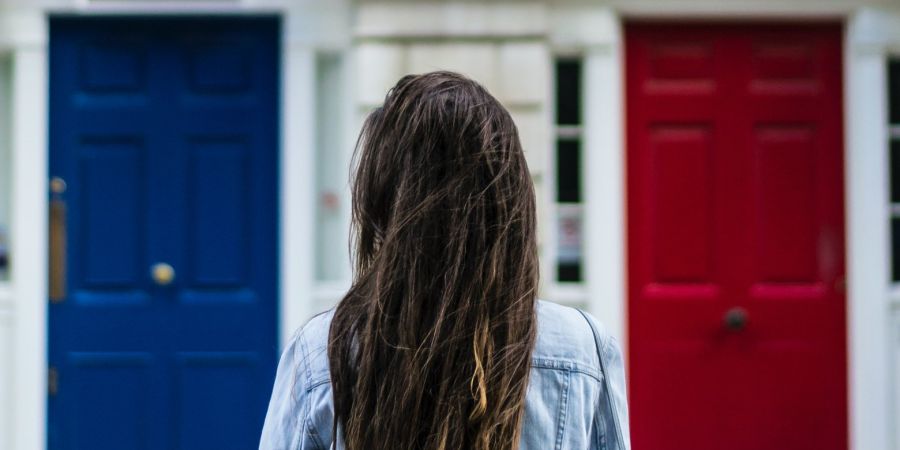 woman outdoors, two doors, red and blue choice