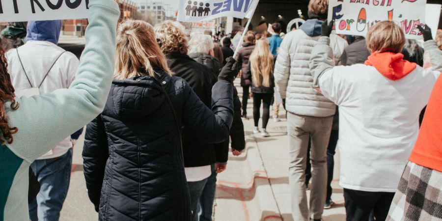 a group of people protesting outdoors, with jackets in the cold