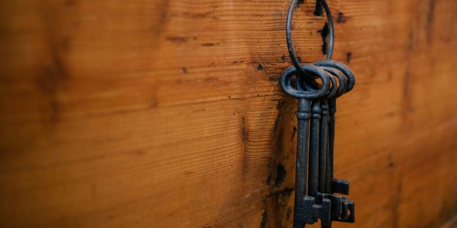 old fashio keys, hanging on a ring, attached to a wood board
