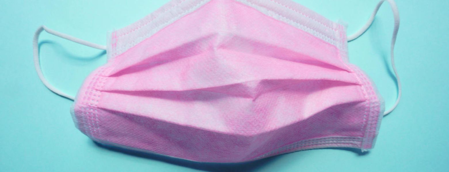 pink medical mask on blue background