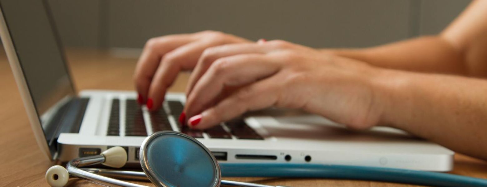 medical professional tryping on a laptop