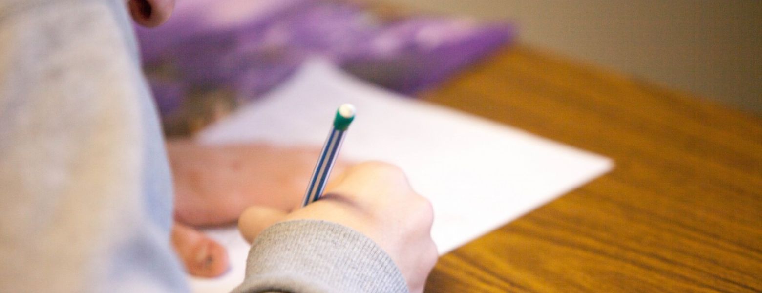 person signing document on a table indoors
