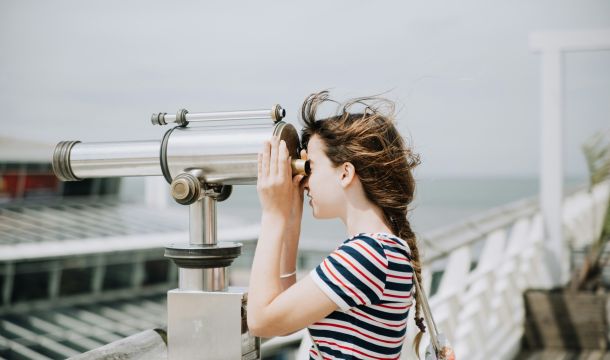 woman looking through a telescope