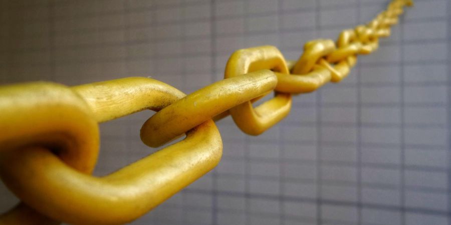 golden chain stretched out from brick like wall