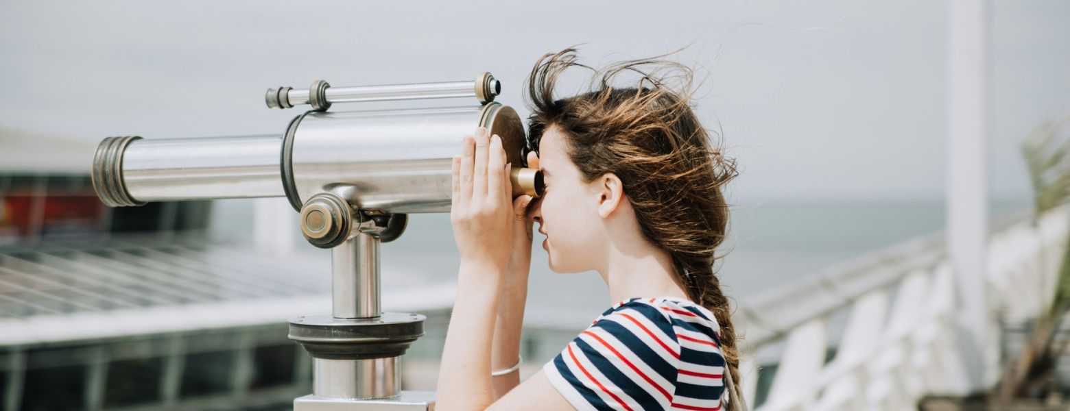 woman looking through a telescope
