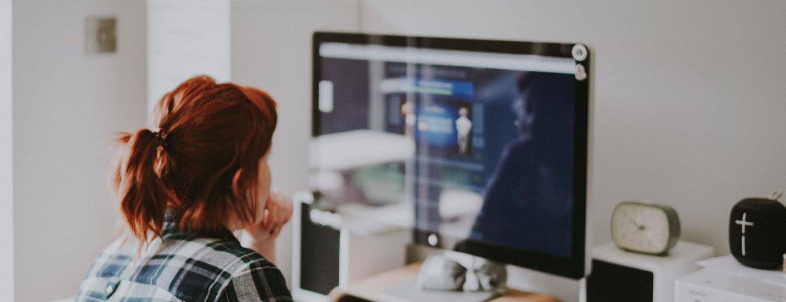 woman at a computer sitting at the desk indoors