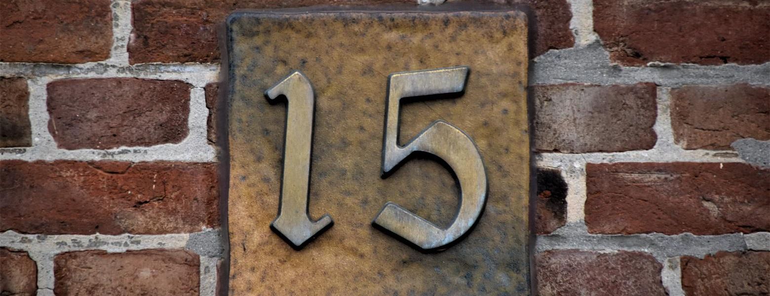 number 15 on a brick wall