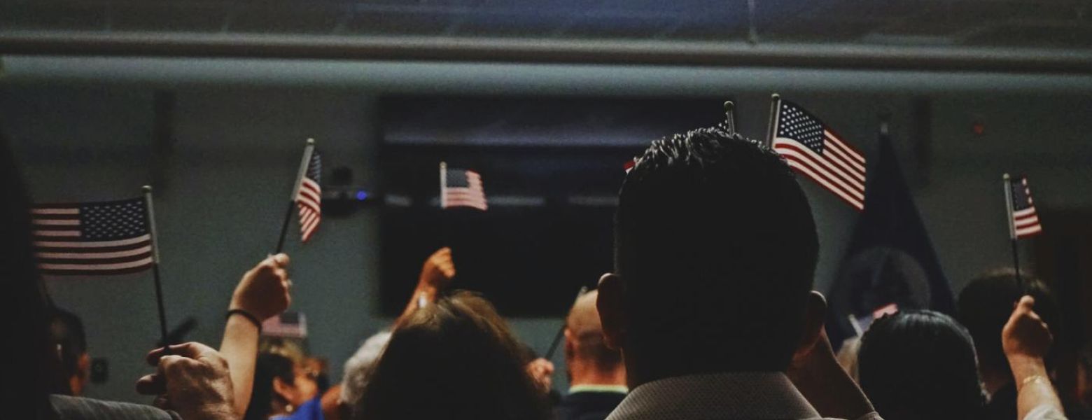 people in a room holding usa flags, indoors