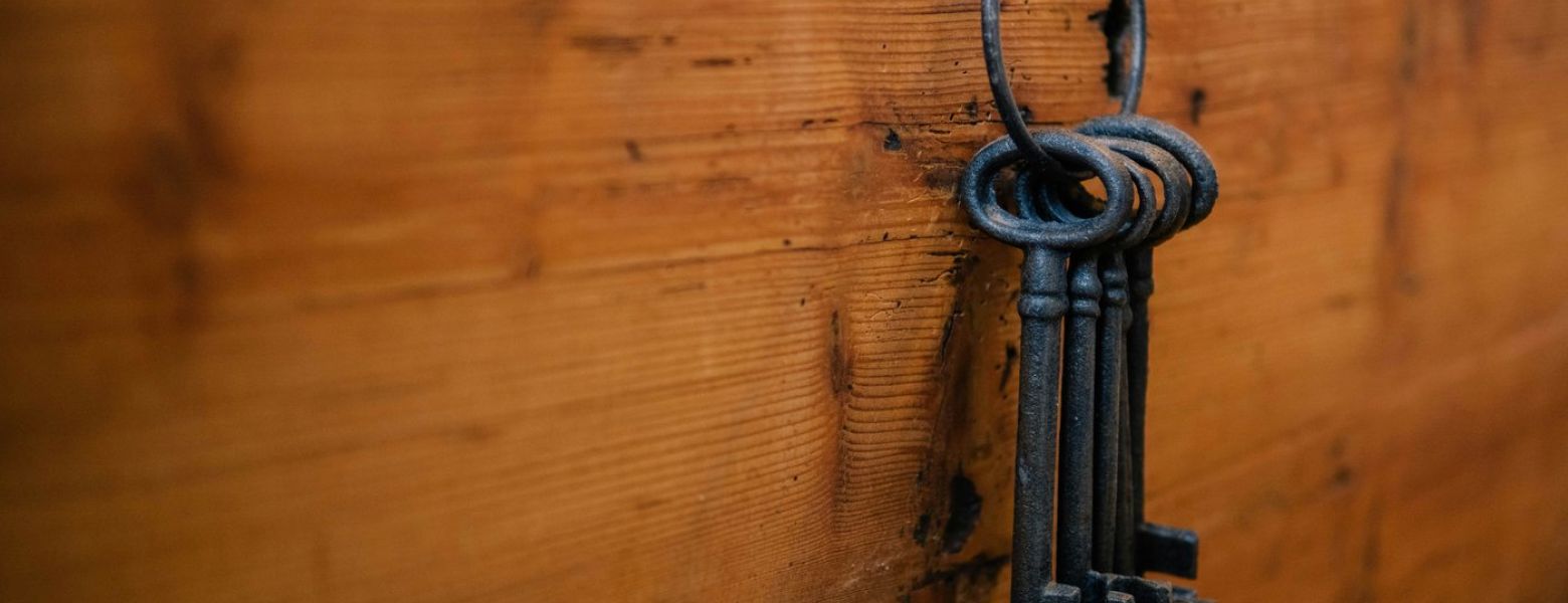 old fashio keys, hanging on a ring, attached to a wood board