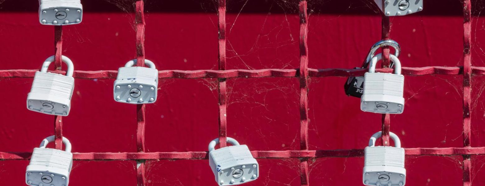 a fence with locks attached, outdoors, red