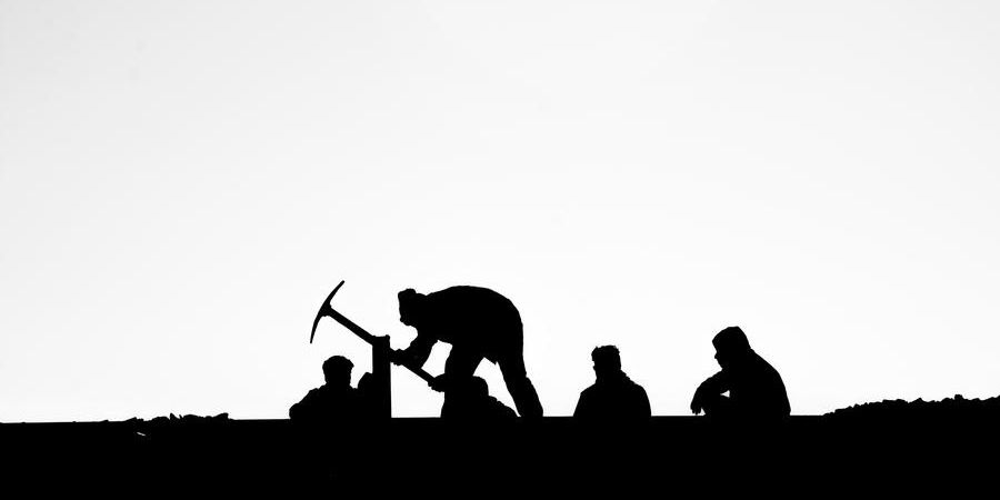 labor working outdoors with pick ax