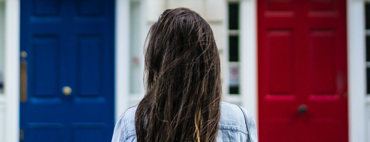 woman outdoors, two doors, red and blue choice