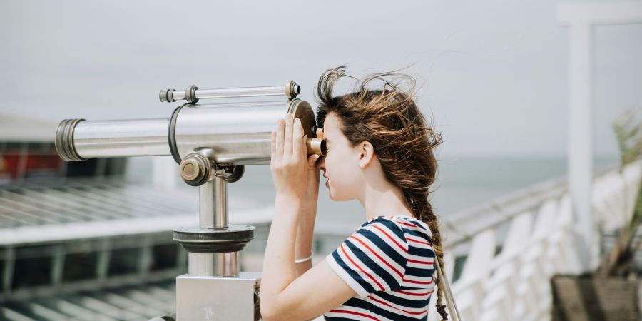 woman looking through a telescope