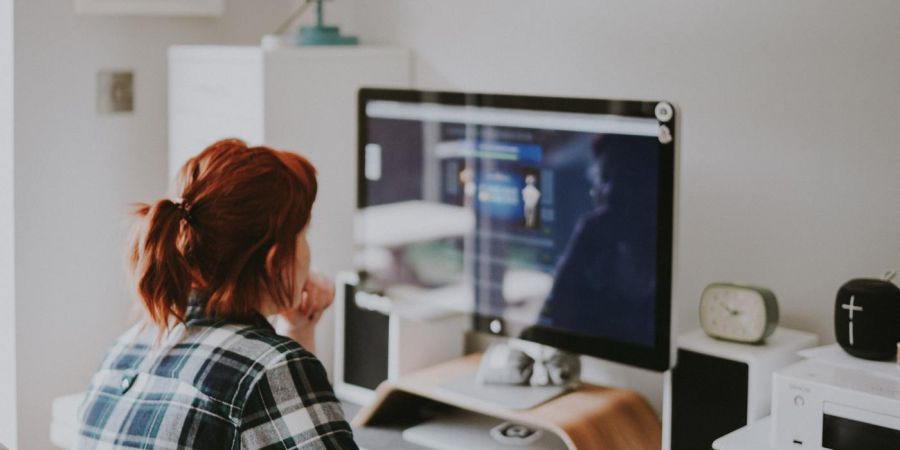 woman at a computer sitting at the desk indoors