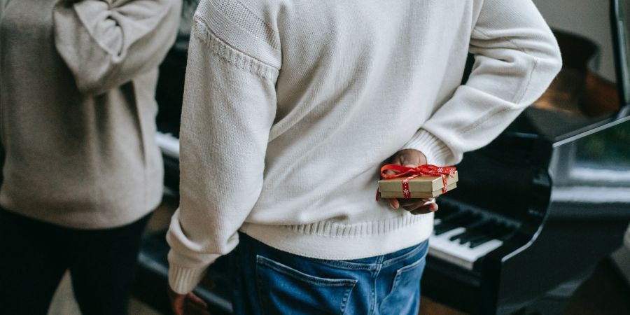 man holding a gift behind his back