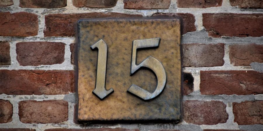 number 15 on a brick wall