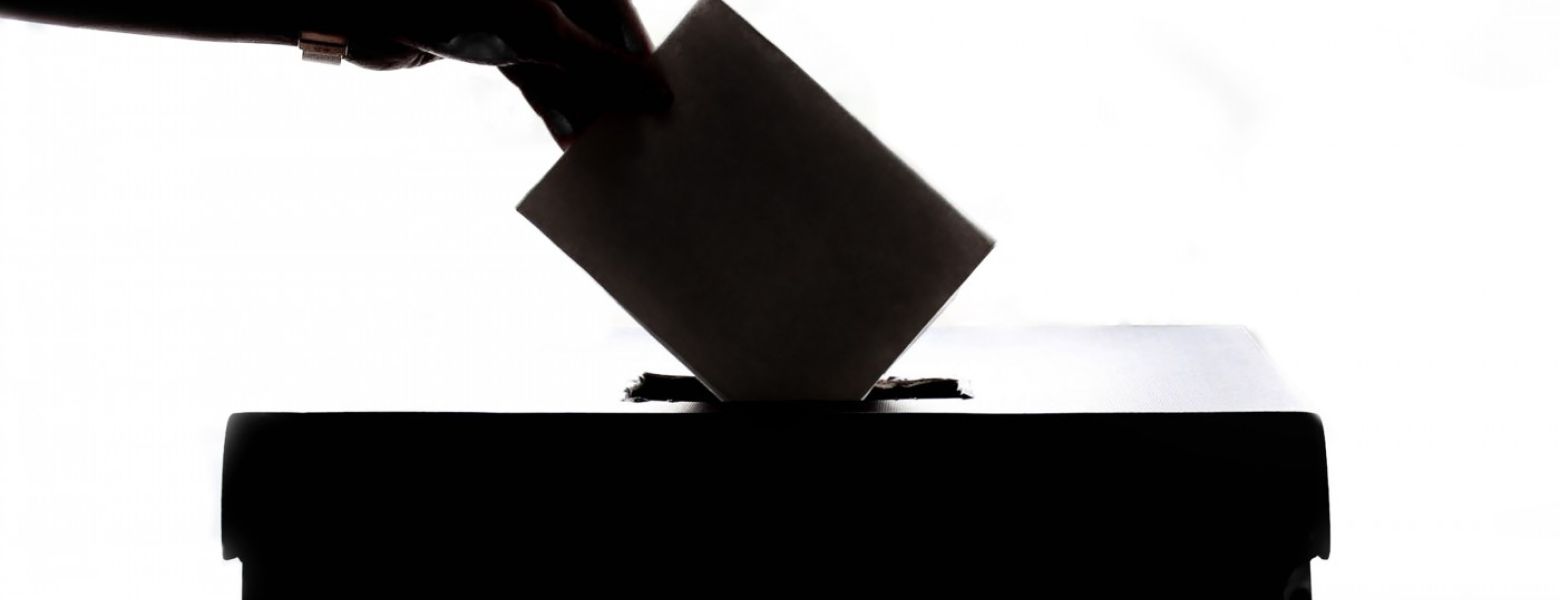 casting a ballot into a box