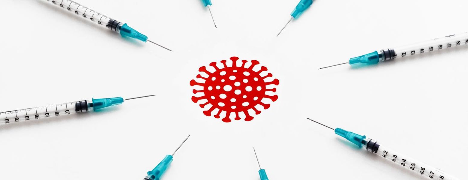 vaccine needles all pointing at red covid virus in the middle