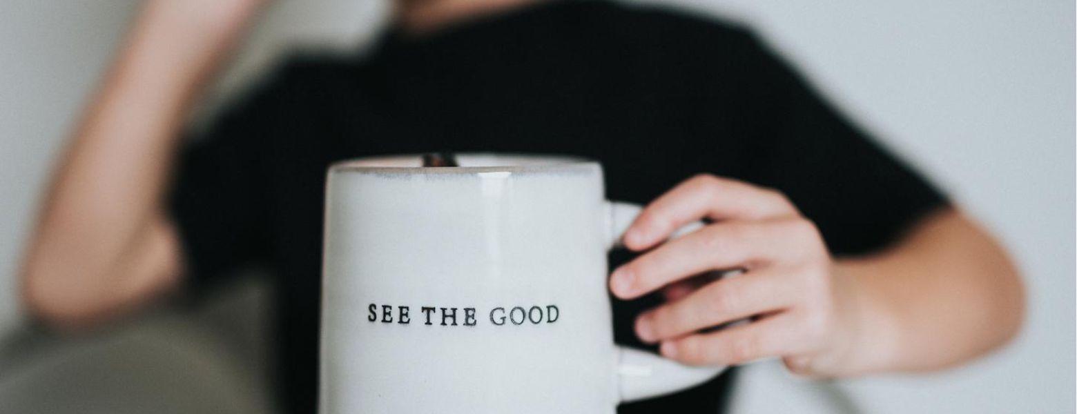 holding a be the good mug, indoors