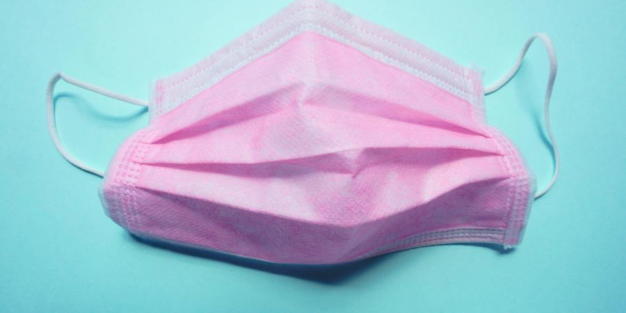 pink medical mask on blue background