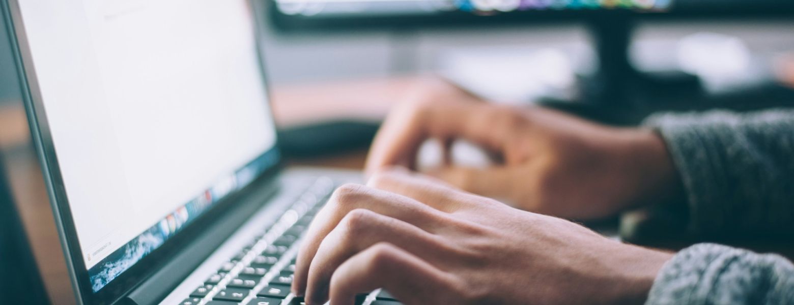 person using a computer at their desk, indoors