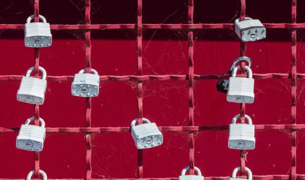 a fence with locks attached, outdoors, red