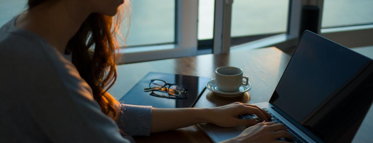 woman using a computer indoors near window