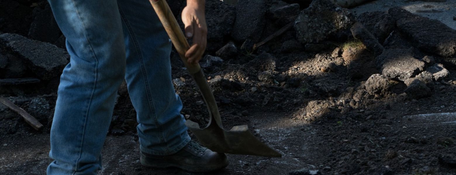 man is digging in the dirt outdoors