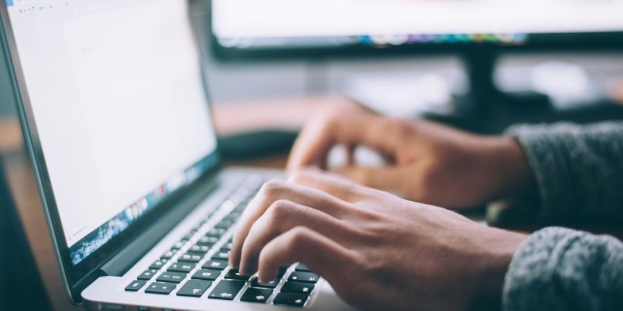 person using a computer at their desk, indoors