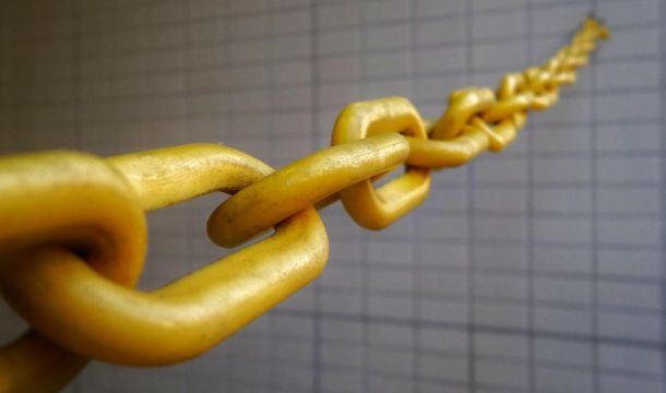 golden chain stretched out from brick like wall