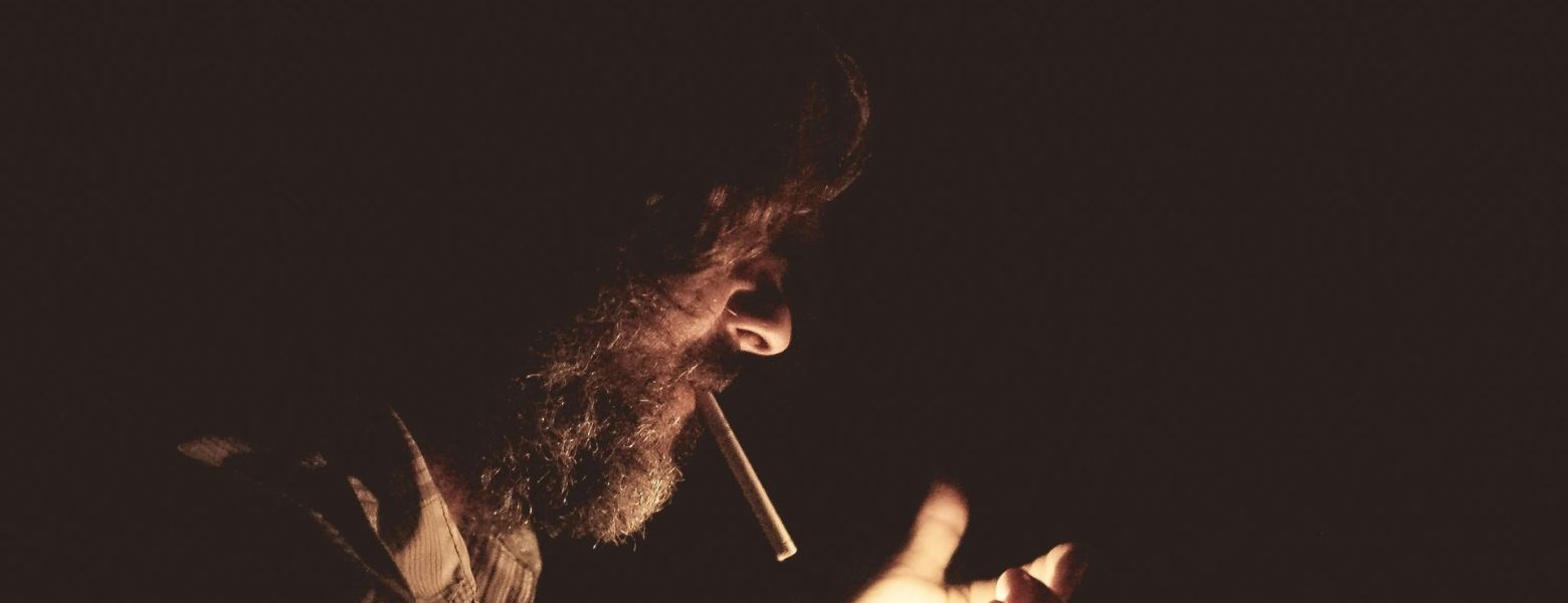 man smoking, in the dark