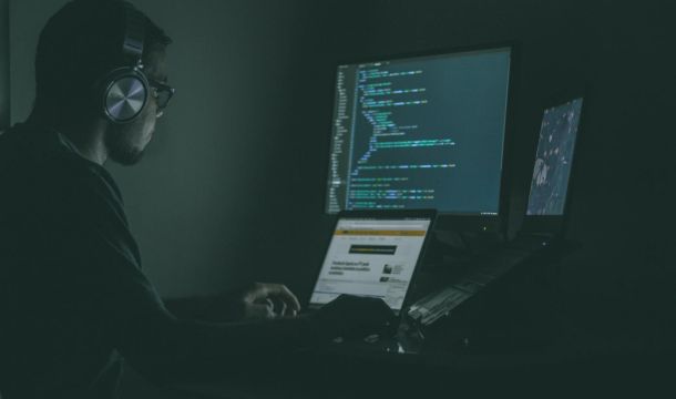 man using a computer in a dark room