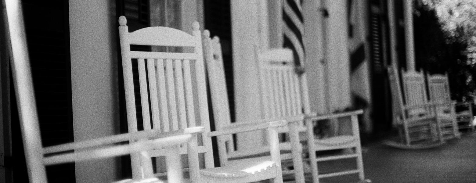 white rocking chairs in front of building, outdoors