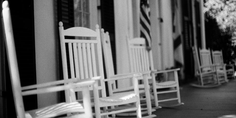 white rocking chairs in front of building, outdoors