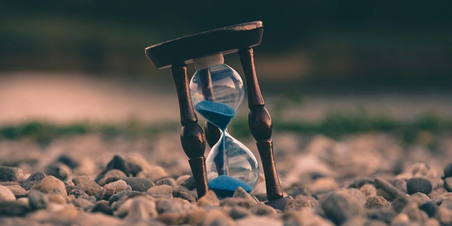 an hourglass sitting on rocks outside