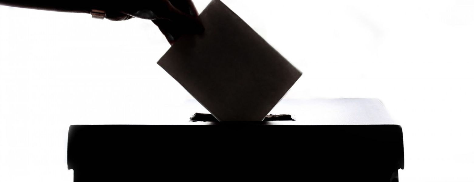 casting a ballot into a box