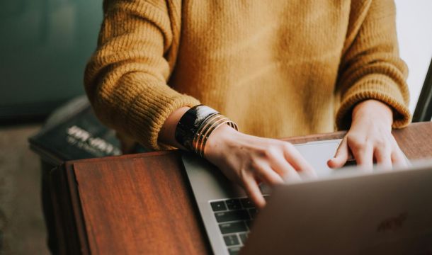 person using a laptop computer on a desk indoors